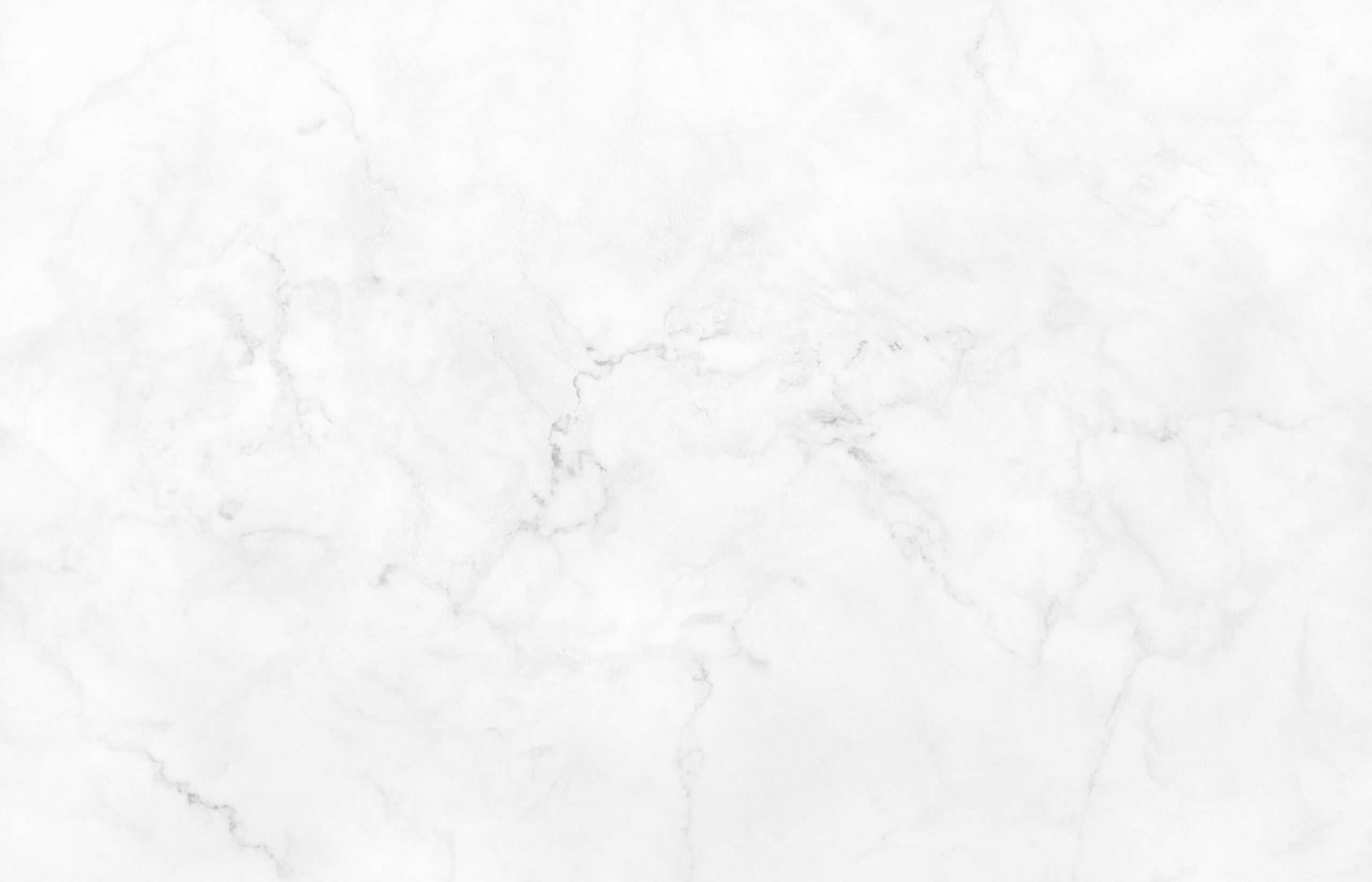 A white marble texture with subtle gray veining. The surface appears smooth and polished, featuring intricate patterns formed by the intersecting natural lines and swirls typical of marble. The overall look is clean and elegant, often used for flooring or countertops.